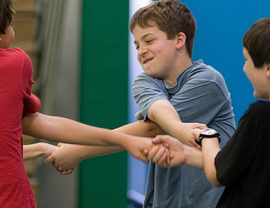 Primary students playing ring around the rosie in the classroom